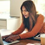 A woman browsing in front of a laptop